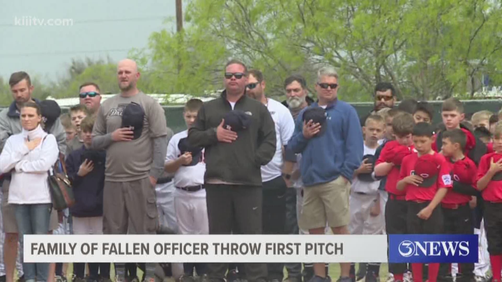 The wife and daughter of Officer Alan McCollum threw out the ceremonial first pitch that kicks off the little league season.