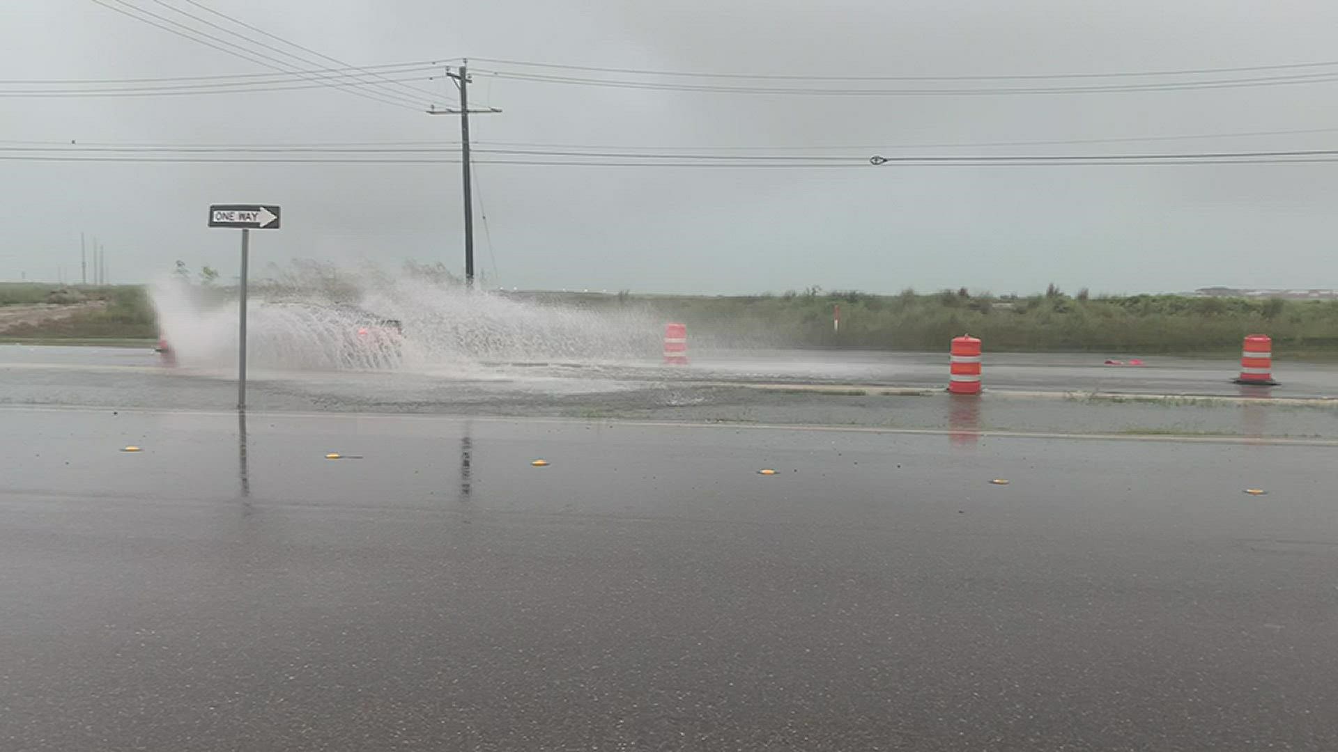 Cars are driving through high water on Park Road 22 on Padre Island.