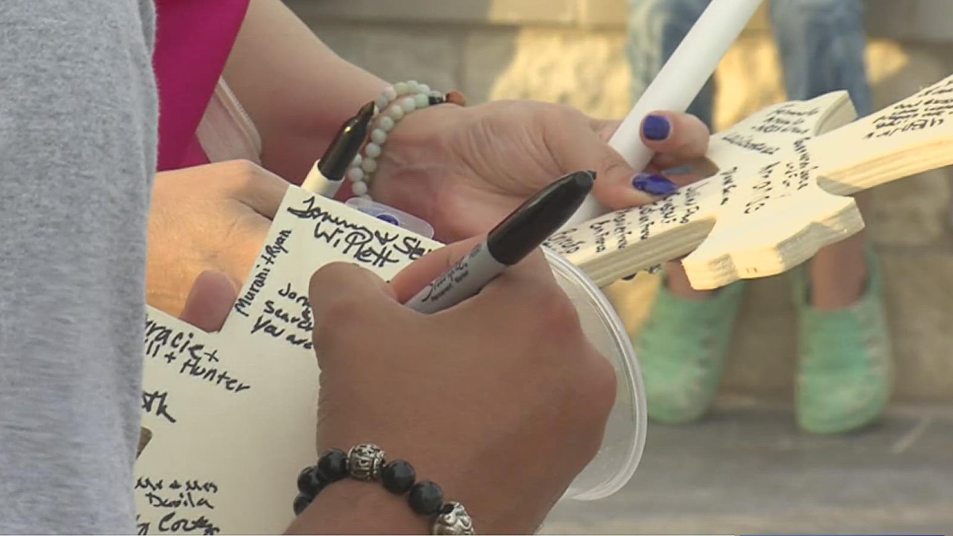 The community gathered Saturday to pay their respects to Caleb Harris by lighting a candle and signing a cross to be presented to the Harris family.