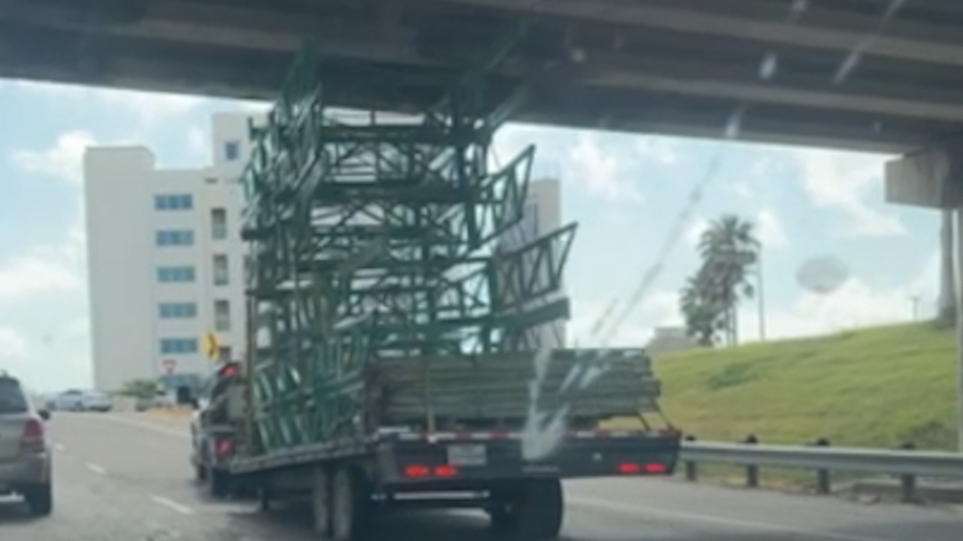 Video shows a truck pulling a trailer with a tall load stuck under an overpass on I37 south, near the Buffalo exit ramp.