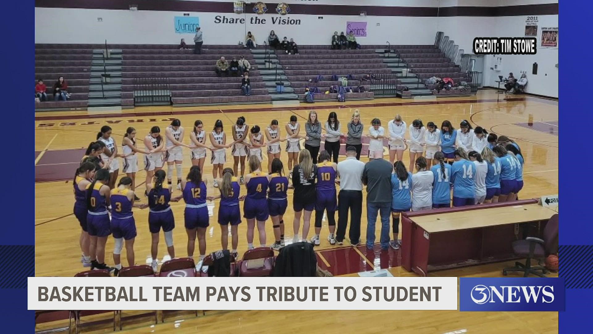 the Pirates coach led her team in honoring student athlete Kacy of Skidmore-Tynan -- by taking a knee and tying blue ribbons to their laces.