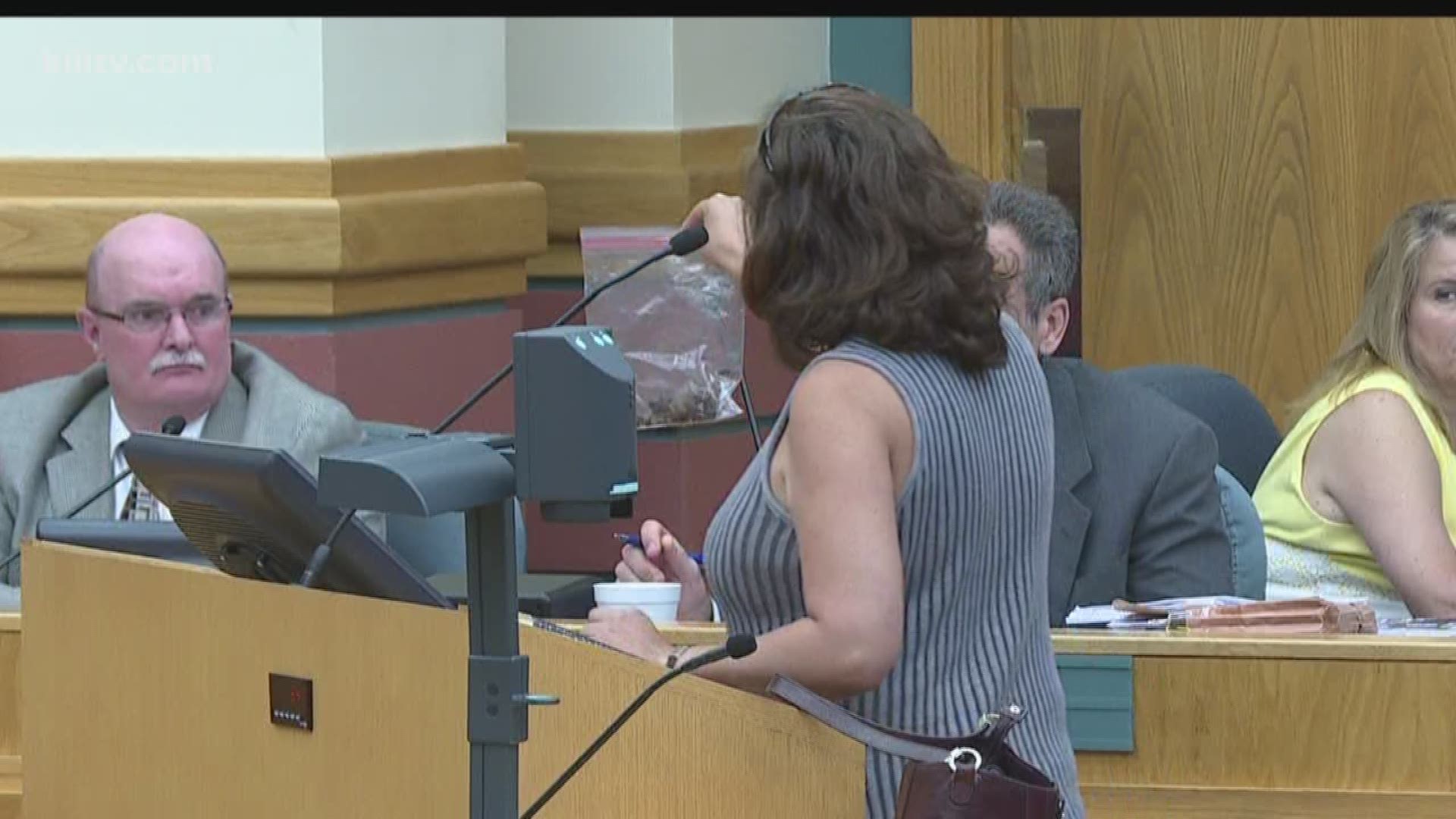The woman handed the bag to interim City Manager Keith Selman to let him examine the evidence.