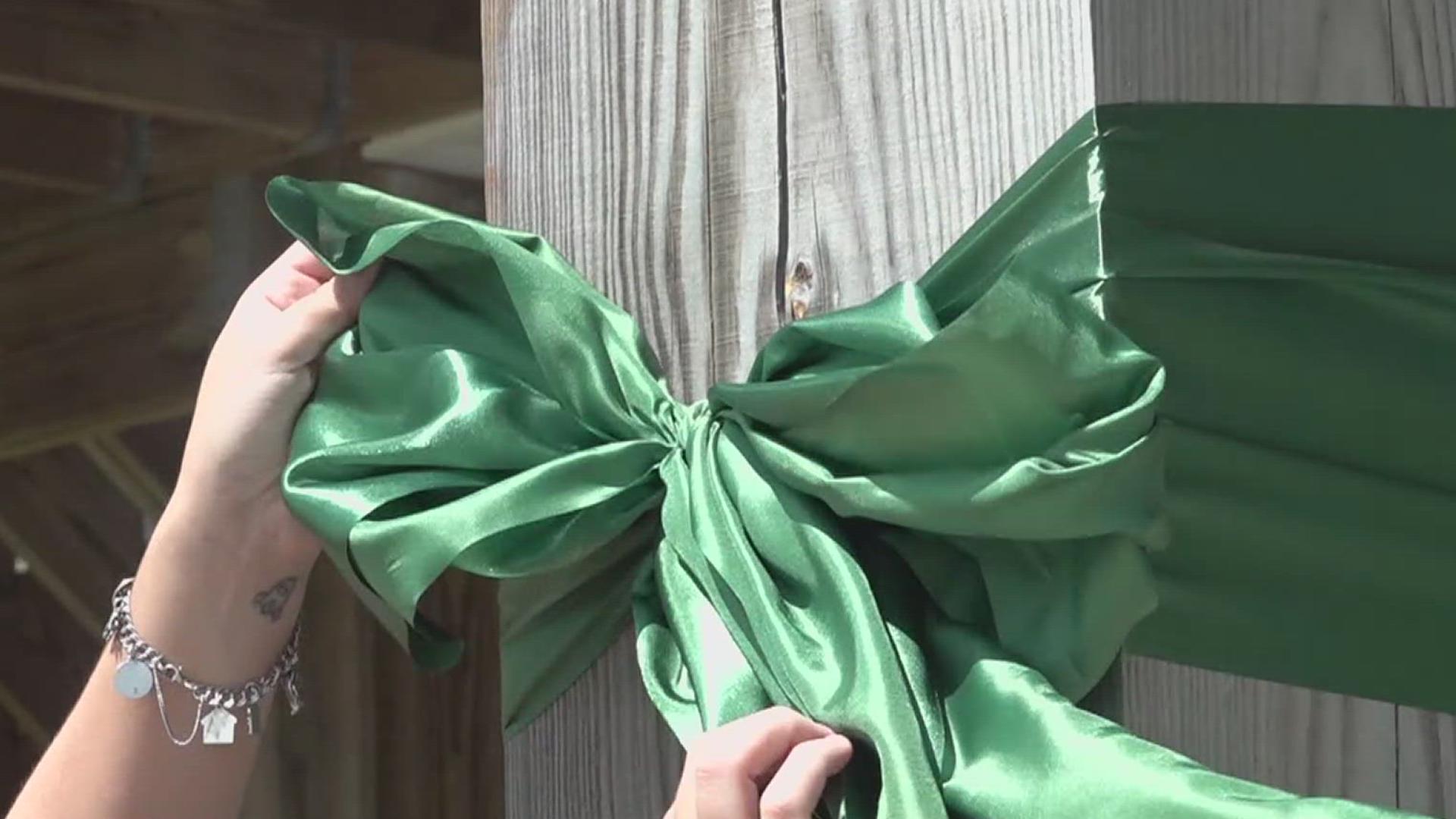 Former Mystic camper spreads support with green ribbons for flood