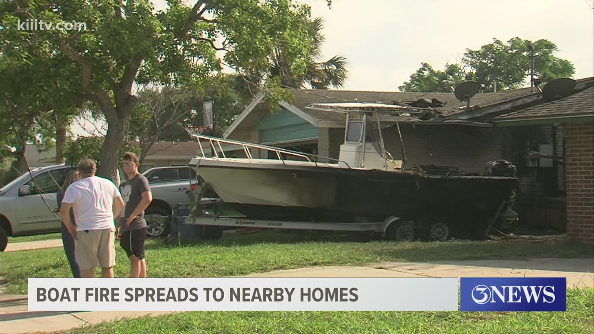 Fire crews worked to prevent a boat fire from spreading to two nearby homes.